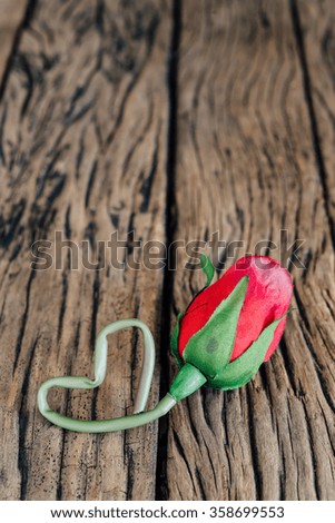 Valentine red rose on old wood background.