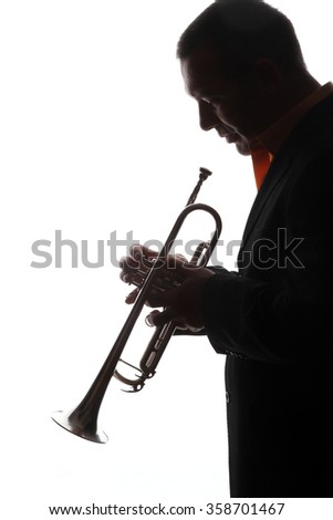 trumpet and a  man - beautiful young handsome male playing a trumpet - back light - shadows - musical instruments - trumpet - valves and tubes - mouthpiece for playing