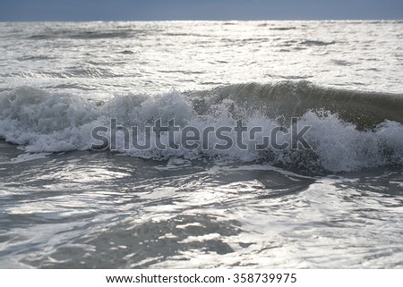 Photo closeup of dramatic grey sea ocean water waves ripples small storm with splashes white spindrifts spoondrifts in dull murky day over seascape background, horizontal picture