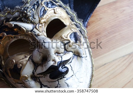 Venetian jester mask on the background of a wooden surface