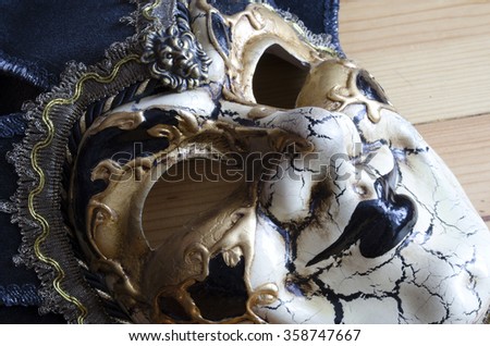 Venetian jester mask on the background of a wooden surface