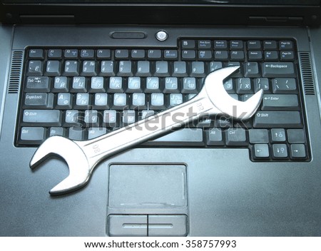 Background of metal spanners on black laptop keyboard Computer with wrench Idea concept  of hacking install complex password cracking notebook repair restrict access for children sites Internet
