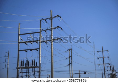 High voltage electricity pole with blue clear sky background