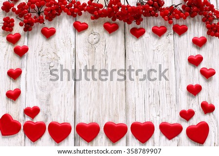 Silk hearts with viburnum on white wooden background 