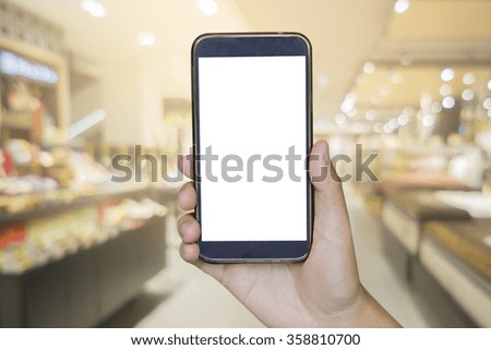 woman hand hold and touch screen smart phone, tablet,cellphone over blurred shopping center or super market background.shopping online.
