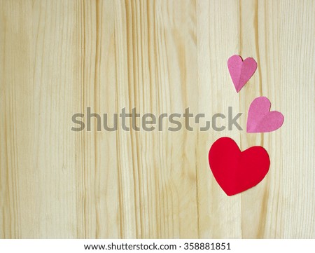 Image of pink and red hearts on a light wooden surface.