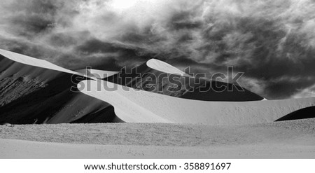 Black and white picture of sand dunes at sunset casting nice shadows in Sossusvlei  in the Namib-Naukluft National Park of Namibia.