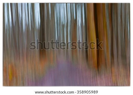 A slow shutter speed coloured photo of trees in a forest showing green, orange leaves and lavender colours with a strong bi-colour filter in Europe
