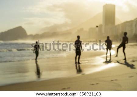 Defocus view of beach football silhouettes playing on the shore of Copacabana Beach at sunset in Rio de Janeiro, Brazil 