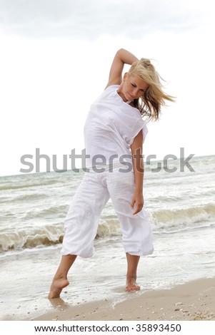 beautiful dancer posing on the sandy sea beach