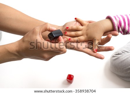 mother applying nail polish to her little girl Royalty-Free Stock Photo #358938704