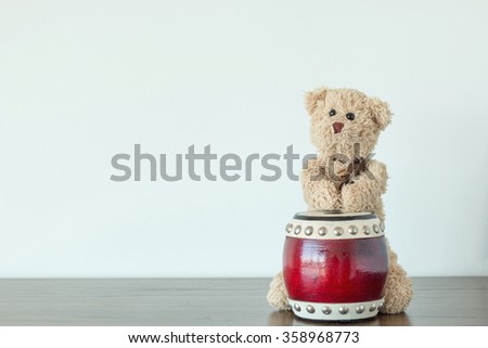 teddy bear is playing drum