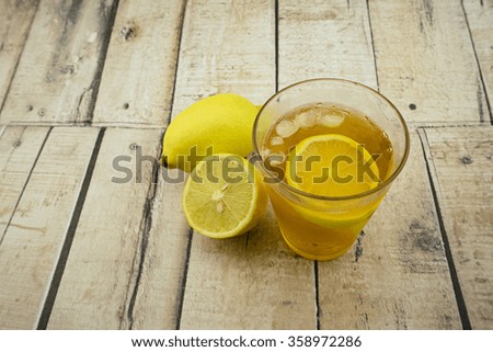 Ice lemon tea on wooden background.