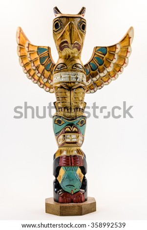 Hand carved wooden American Indian eagle and wolf Totem Pole with wings isolated on a white background Royalty-Free Stock Photo #358992539