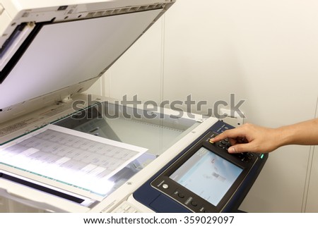 someone copy document at copy machine.non-English text mean "CAUTION Do not stare at light.It may cause discomfort or irritation to your eyes,"