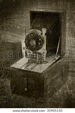 antique folding camera on grunge background