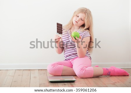 happy girl  with scales, fruits and chocolate