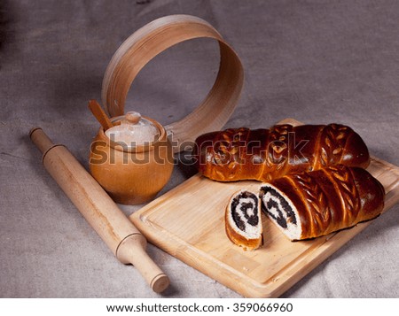 Vintage still life with wooden utensils and a roll with poppy seeds