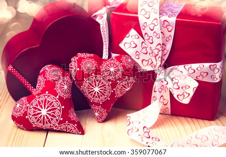 Valentine's day background with red hearts. Gifts on wooden table.