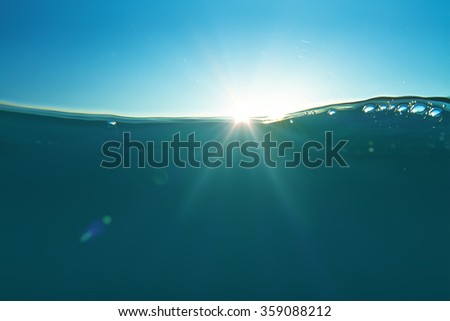 Ocean water design template with underwater part and sunset skylight splitted by waterline with air bubbles.