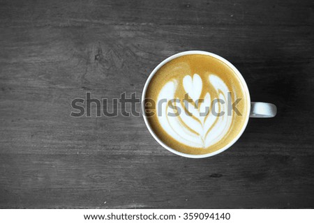 A Cup of hot latte art coffee on wooden table
