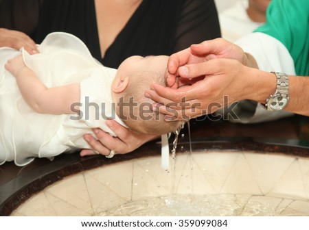 Newborn baby baptism by water with hands of priest Royalty-Free Stock Photo #359099084