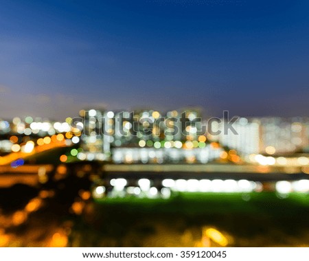 Blurred abstract background aerial view of Eunos neighborhood in Singapore at blue hour. Colorful bokeh from city lights, electric train and car headlights in traffic. Glow urban cityscape background.