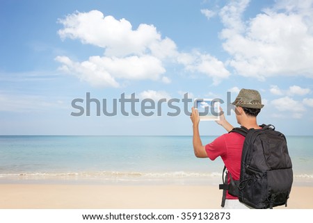 Hand male asian holding tablet taking picture of beautiful landscape scenery background,Concept tourism in holiday