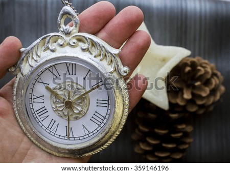 Silver clock on a gray background with candles and cones