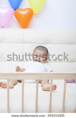 Chinese baby boy playing on a sofa, shot in Beijing, China