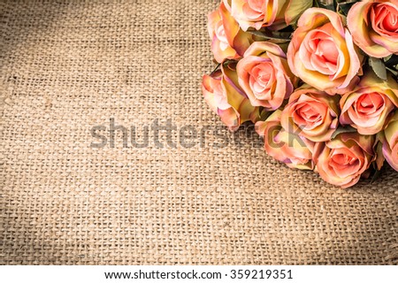 Valentine roses on rustic jute background. Flowers backgrounds.