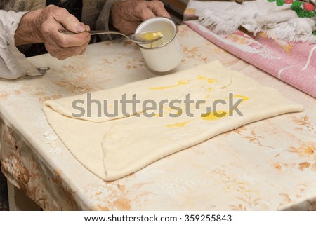 Grandmother making puff pastry on the table.