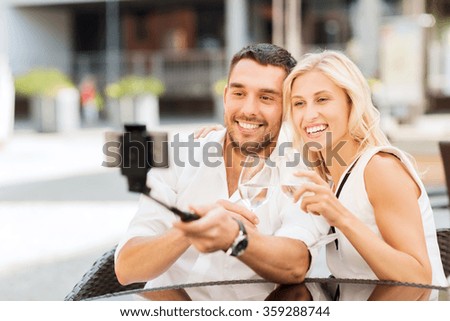 happy couple taking selfie with smartphone at cafe