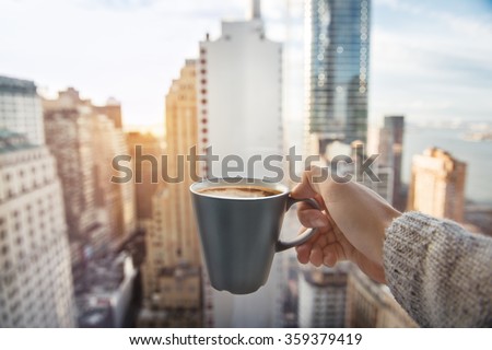 Man holding coffee cup in luxury penthouse apartments with view to New York City Manhattan downtown at the morning Royalty-Free Stock Photo #359379419