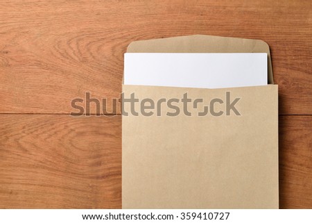 Blank paper and envelope on wooden background