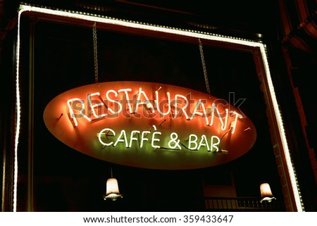 Neon sign reading Restaurant, caffe and bar hanging window with lights around the window