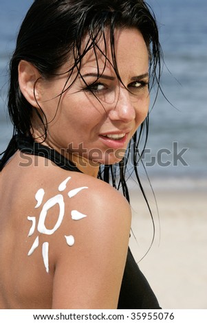 Portrait of attractive woman with sun-shaped sun cream