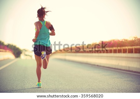 Young woman runner running on city bridge road Royalty-Free Stock Photo #359568020