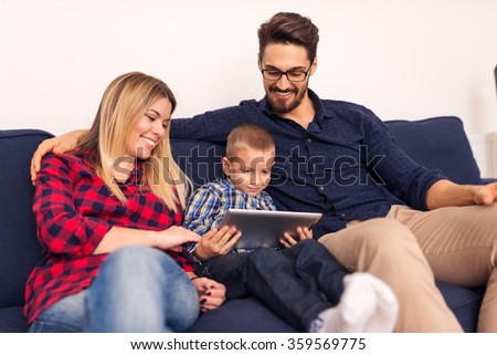 Shot of a happy family watching cartoons on a tablet.