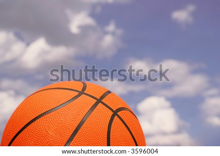 Orange basketball against the  cloudy sky