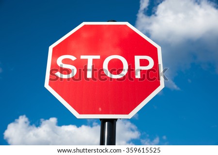 Red stop traffic street sign on blue sky background