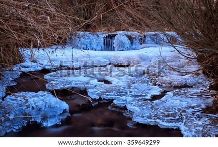 Frozen Small River with Rocks and Icicles