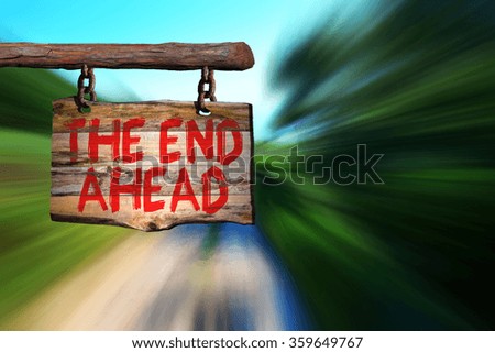 The end ahead motivational phrase sign on old wood with blurred background