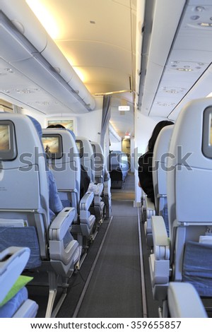Passengers in the tourist class sitting in their seats of the airplane