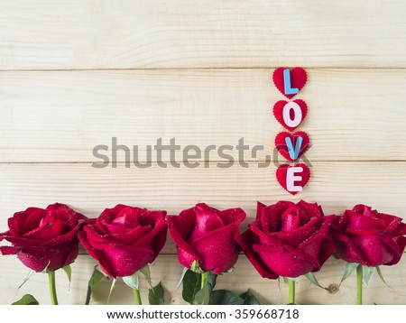 Red rose flower and word "Love" on wood background, Love concept for Valentines Day