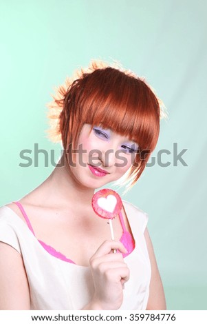 girl in satin dress with candy heart on colored background