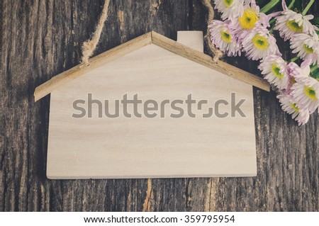 Blank wooden sign with house shape and Mum flower on old wooden table with vintage and vignette tone