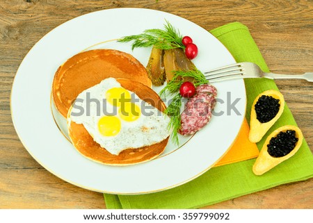 Pancakes with Quail Eggs, Cold Meats, Pastry Spoon with Black Caviar. Studio Photo