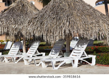 Beach chairs and umbrell at beautiful resort pool