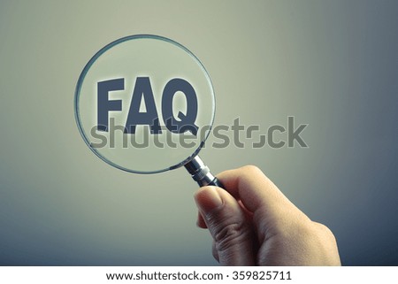 Hand holding a magnifying glass with text FAQ.